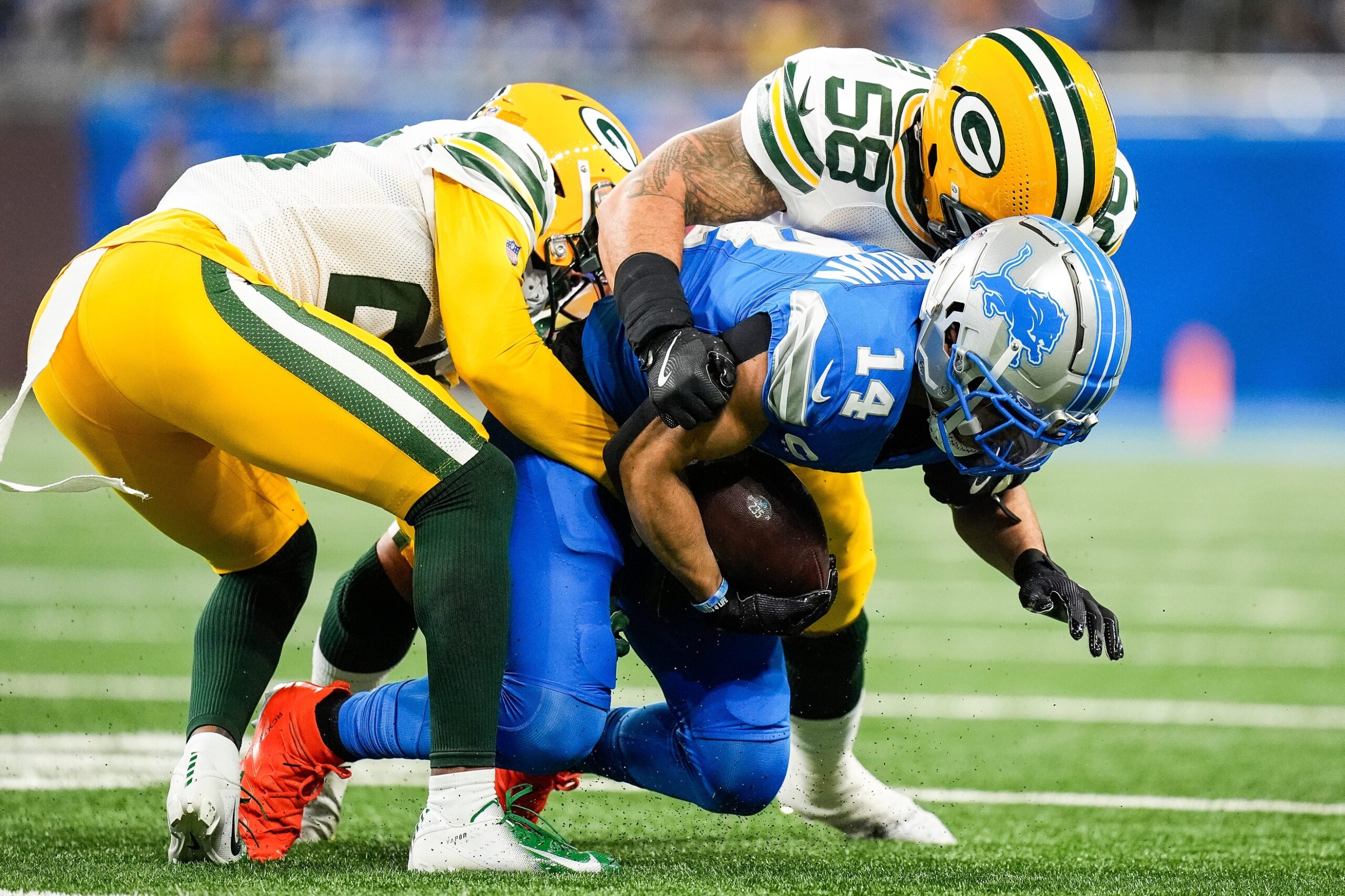 Detroit Lions wide receiver Amon-Ra St. Brown (14) makes a catch against Green Bay Packers cornerback Corey Ballentine (26), left, and linebacker Isaiah McDuffie (58) during the first half at Ford Field in Detroit on Thursday, Dec. 5, 2024. © Junfu Han / USA TODAY NETWORK via Imagn Images