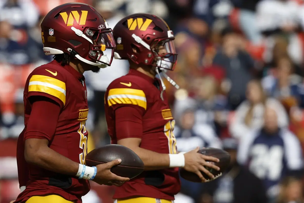 Nov 24, 2024; Landover, Maryland, USA; Washington Commanders quarterback Jayden Daniels (5) and Commanders quarterback Marcus Mariota (18) stand on the field during warmup prior to the game against the Dallas Cowboys at Northwest Stadium. Mandatory Credit: Geoff Burke-Imagn Images