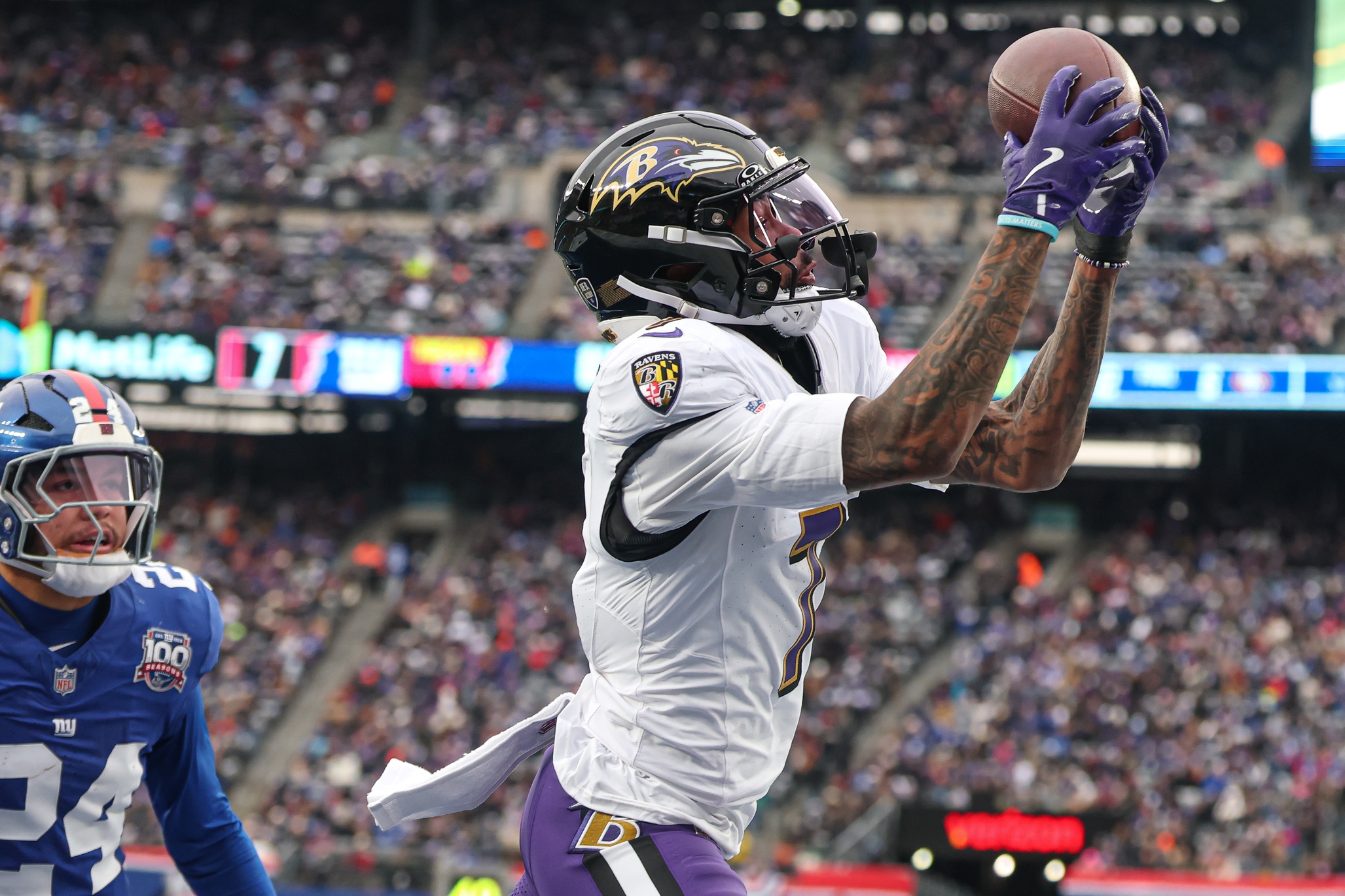 Dec 15, 2024; East Rutherford, New Jersey, USA; Baltimore Ravens wide receiver Rashod Bateman (7) catches a touchdown pass in front of New York Giants safety Dane Belton (24) during the first half at MetLife Stadium. Mandatory Credit: Vincent Carchietta-Imagn Images