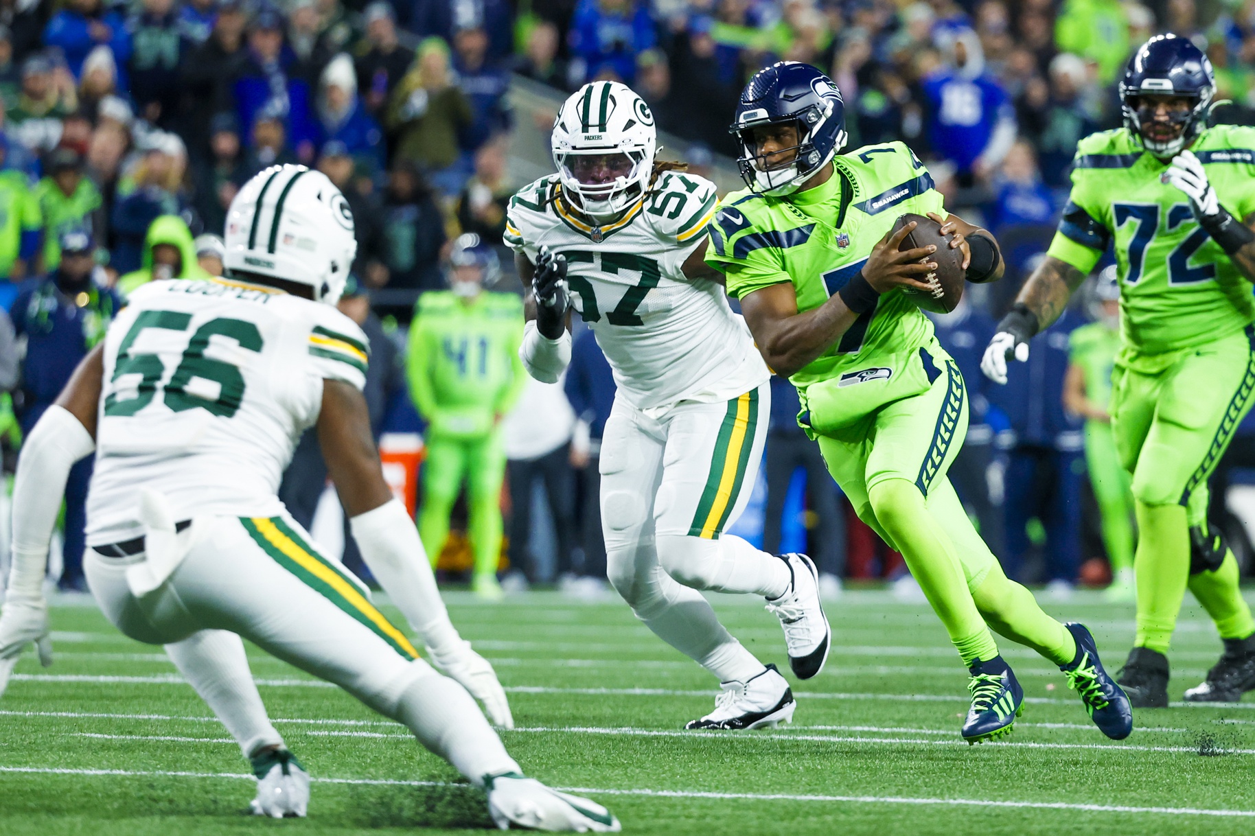 Dec 15, 2024; Seattle, Washington, USA; Seattle Seahawks quarterback Geno Smith (7) rushes away from Green Bay Packers defensive end Brenton Cox Jr. (57) during the second quarter at Lumen Field. Mandatory Credit: Joe Nicholson-Imagn Images