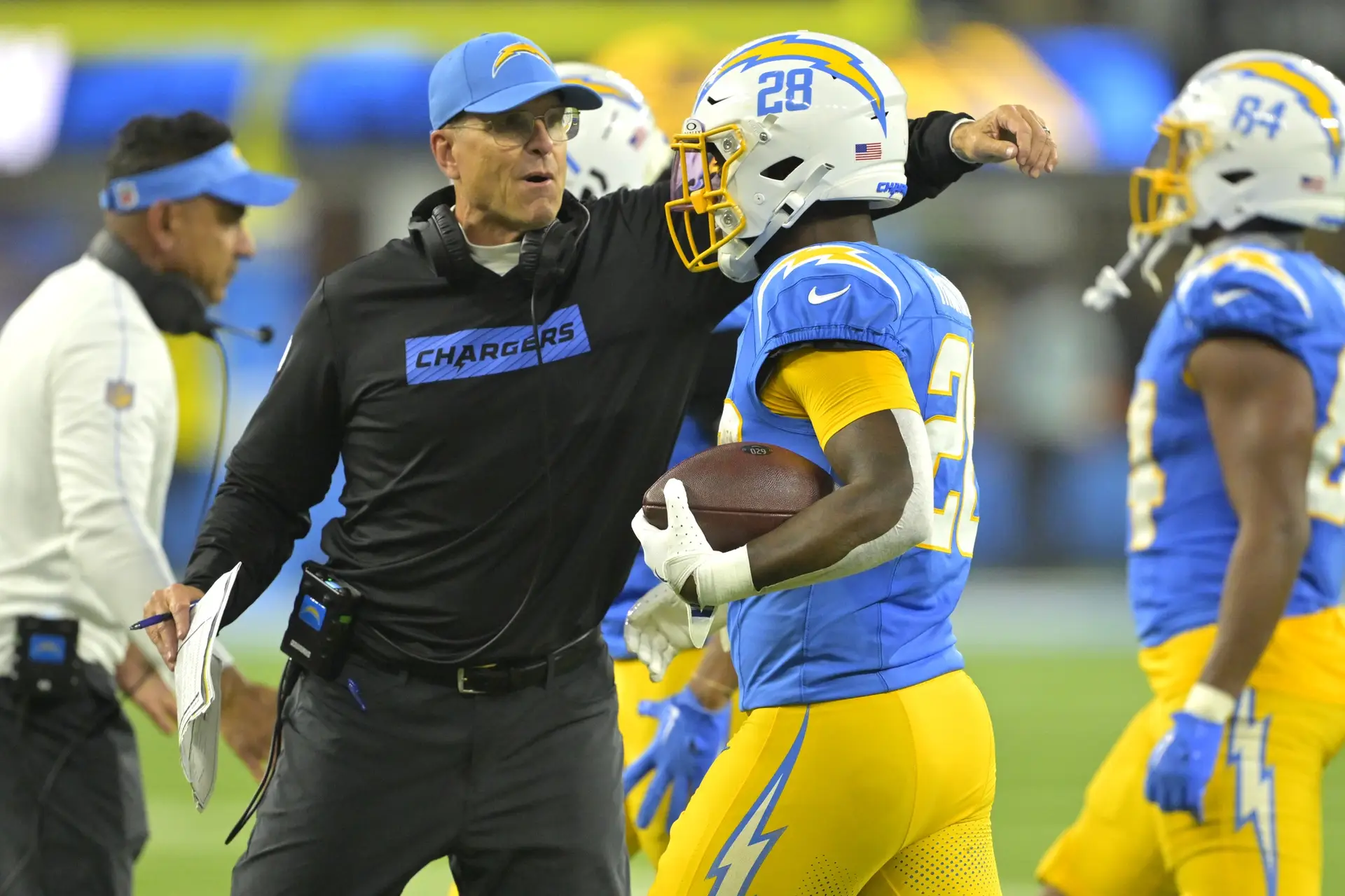 Dec 19, 2024; Inglewood, California, USA; Los Angeles Chargers head coach Jim Harbaugh congratulates running back Hassan Haskins (28) after a touchdown in the second half against the Denver Broncos at SoFi Stadium. Mandatory Credit: Jayne Kamin-Oncea-Imagn Images