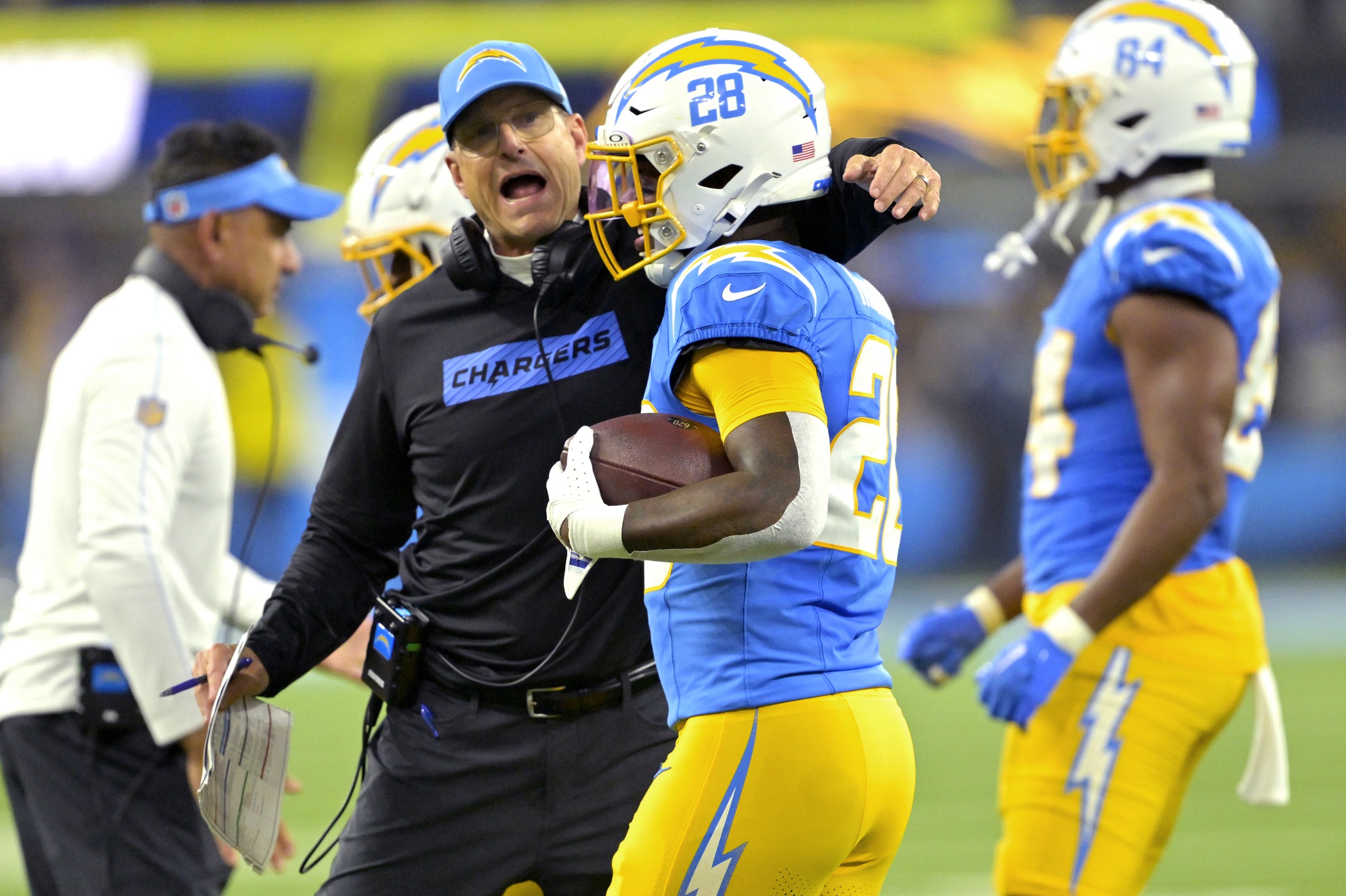 Dec 19, 2024; Inglewood, California, USA; Los Angeles Chargers head coach Jim Harbaugh congratulates running back Hassan Haskins (28) after a touchdown in the second half against the Denver Broncos at SoFi Stadium. Mandatory Credit: Jayne Kamin-Oncea-Imagn Images