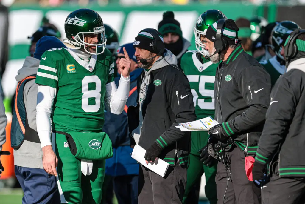 Dec 22, 2024; East Rutherford, New Jersey, USA; New York Jets quarterback Aaron Rodgers (8) talks with head coach Jeff Ulbrich during the first half against the Los Angeles Rams at MetLife Stadium. Mandatory Credit: Vincent Carchietta-Imagn Images