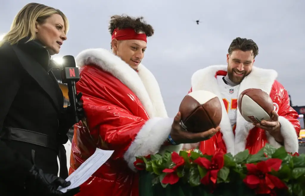 Patrick Mahomes (15) and tight end Travis Kelce (87) look at football cakes while being interviewed