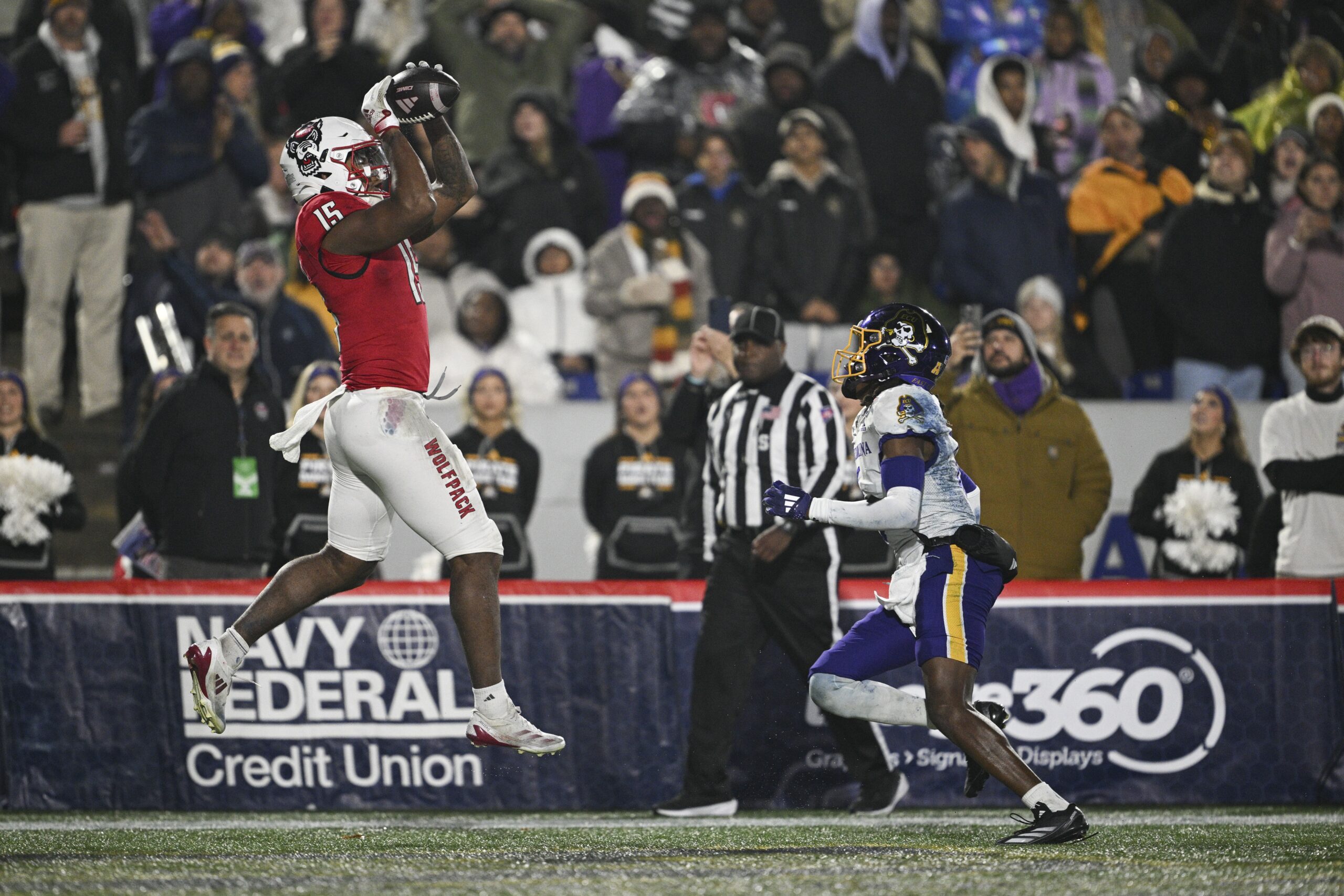 Dec 28, 2024; Annapolis, MD, USA; North Carolina State Wolfpack tight end Justin Joly (15) catches a pass for a touchdown as East Carolina Pirates defensive back Dontavius Nash (6) looks on during the second half of the Go Bowling Military Bowl at Navy-Marine Corps Memorial Stadium. Mandatory Credit: Tommy Gilligan-Imagn Images college football