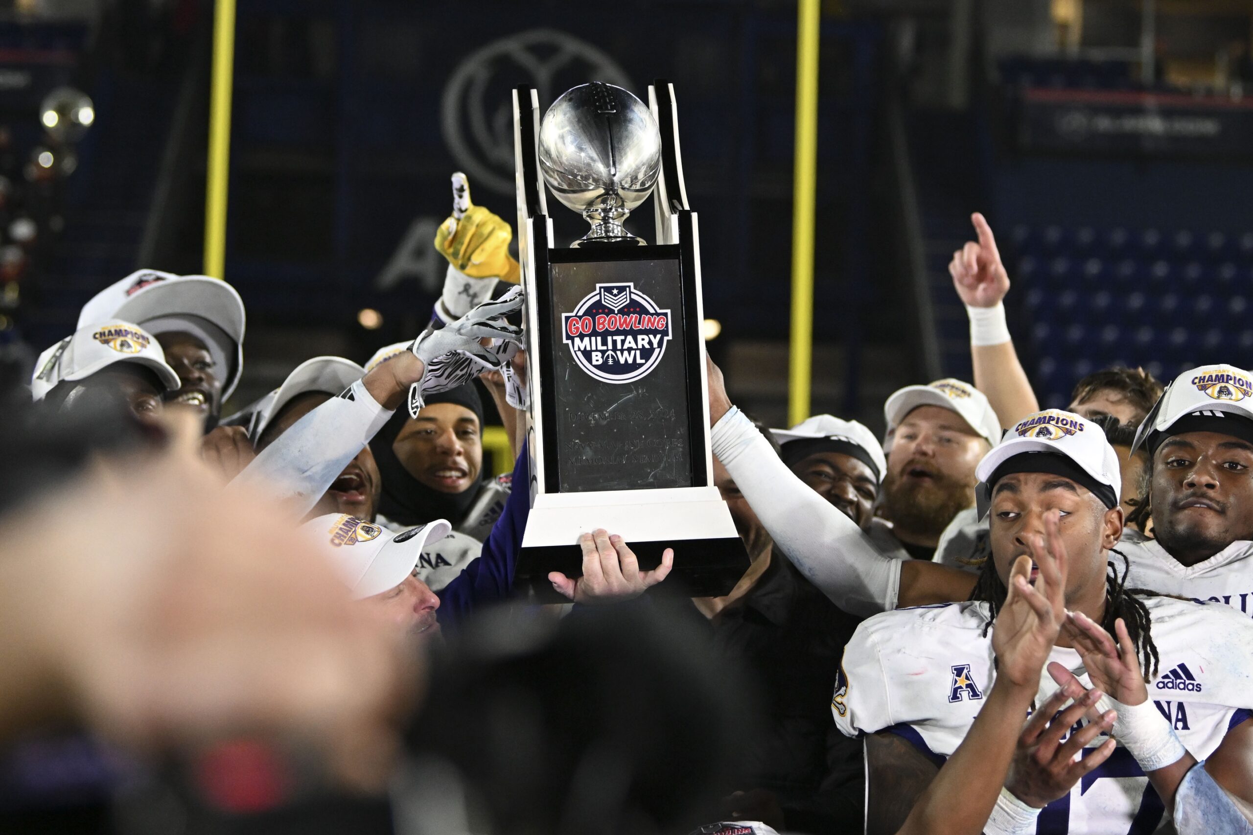 Dec 28, 2024; Annapolis, MD, USA; East Carolina Pirates hoists the Go Bowling Military Bowl trophy after defeating North Carolina State Wolfpack at Navy-Marine Corps Memorial Stadium. Mandatory Credit: Tommy Gilligan-Imagn Images