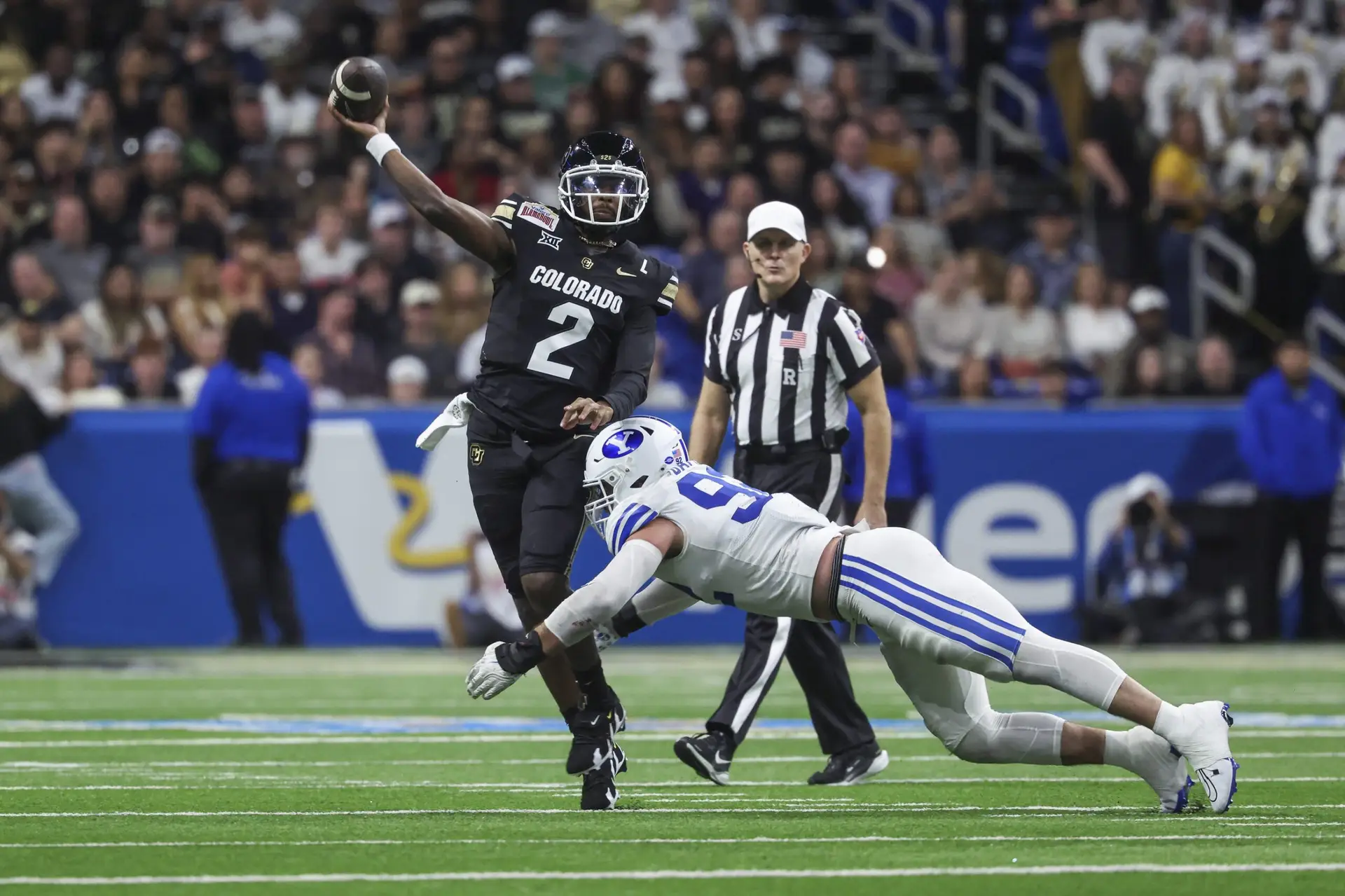 Colorado Buffaloes quarterback Shedeur Sanders (2) attempts a pass as Brigham Young Cougars defensive end Tyler Batty (92) attempts to make a tackle