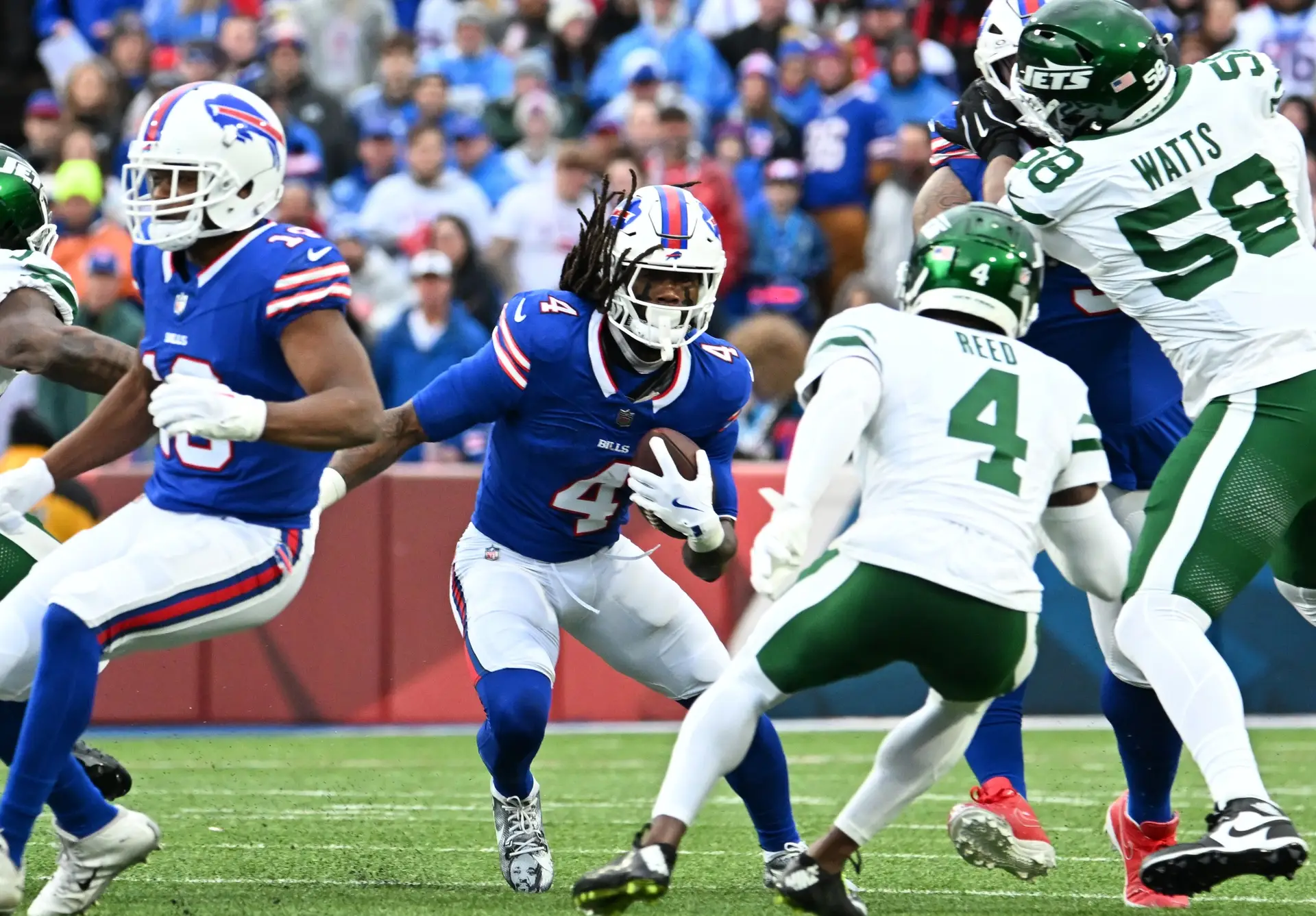 Dec 29, 2024; Orchard Park, New York, USA; Buffalo Bills running back James Cook (4) faces New York Jets cornerback D.J. Reed (4) during a run in the first quarter at Highmark Stadium. Mandatory Credit: Mark Konezny-Imagn Images