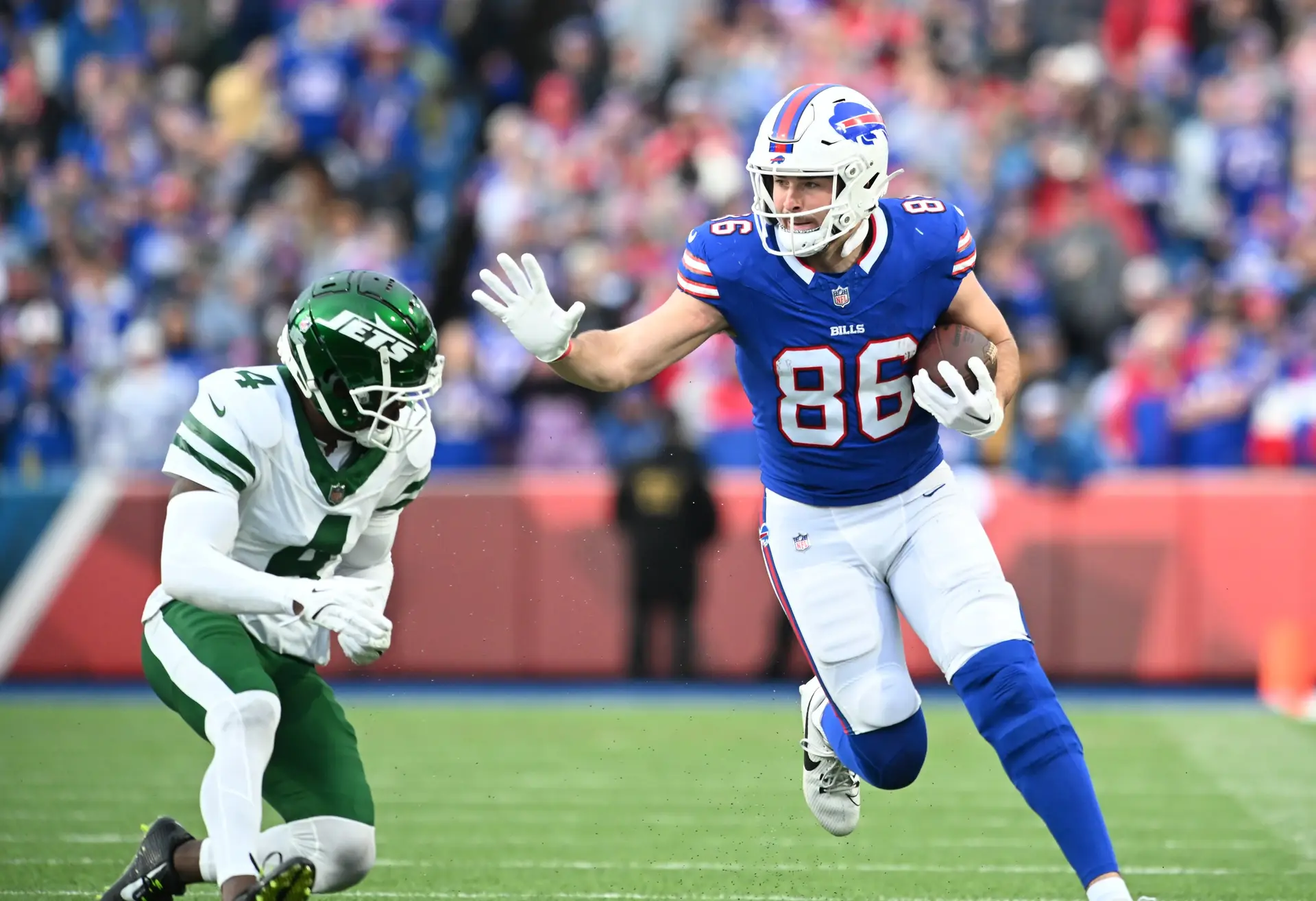 Dec 29, 2024; Orchard Park, New York, USA; Buffalo Bills tight end Dalton Kincaid (86) tries to avoid a tackle by New York Jets cornerback D.J. Reed (4) after making a catch in the third quarter at Highmark Stadium. Mandatory Credit: Mark Konezny-Imagn Images