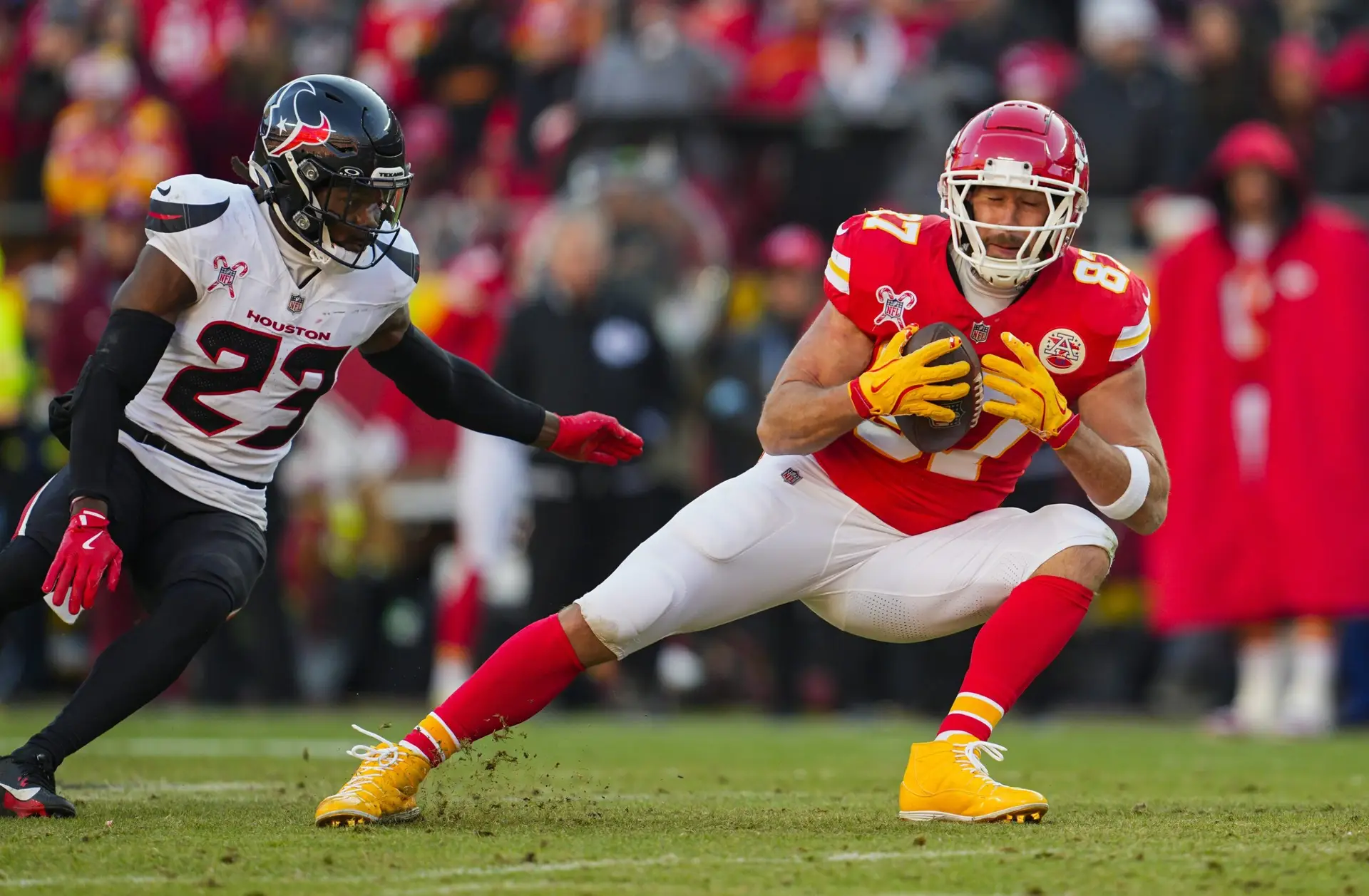 Dec 21, 2024; Kansas City, Missouri, USA; Kansas City Chiefs tight end Travis Kelce (87) catches a pass against Houston Texans safety Eric Murray (23) during the second half at GEHA Field at Arrowhead Stadium. Mandatory Credit: Jay Biggerstaff-Imagn Images