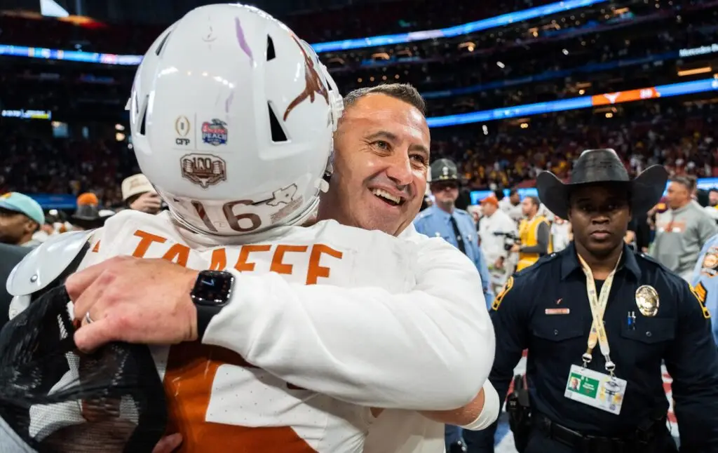 Texas Longhorns head coach Steve Sarkisian embraces Texas Longhorns defensive back Michael Taaffe (16)