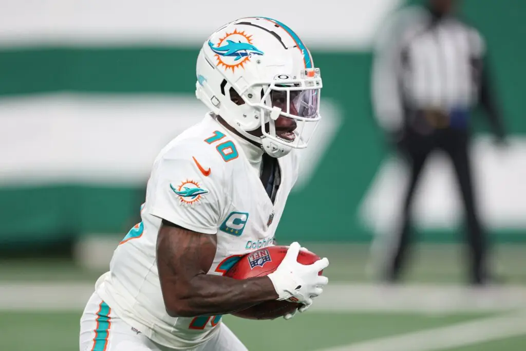 Jan 5, 2025; East Rutherford, New Jersey, USA; Miami Dolphins wide receiver Tyreek Hill (10) returns punt during the first half against the New York Jets at MetLife Stadium. Mandatory Credit: Vincent Carchietta-Imagn Images