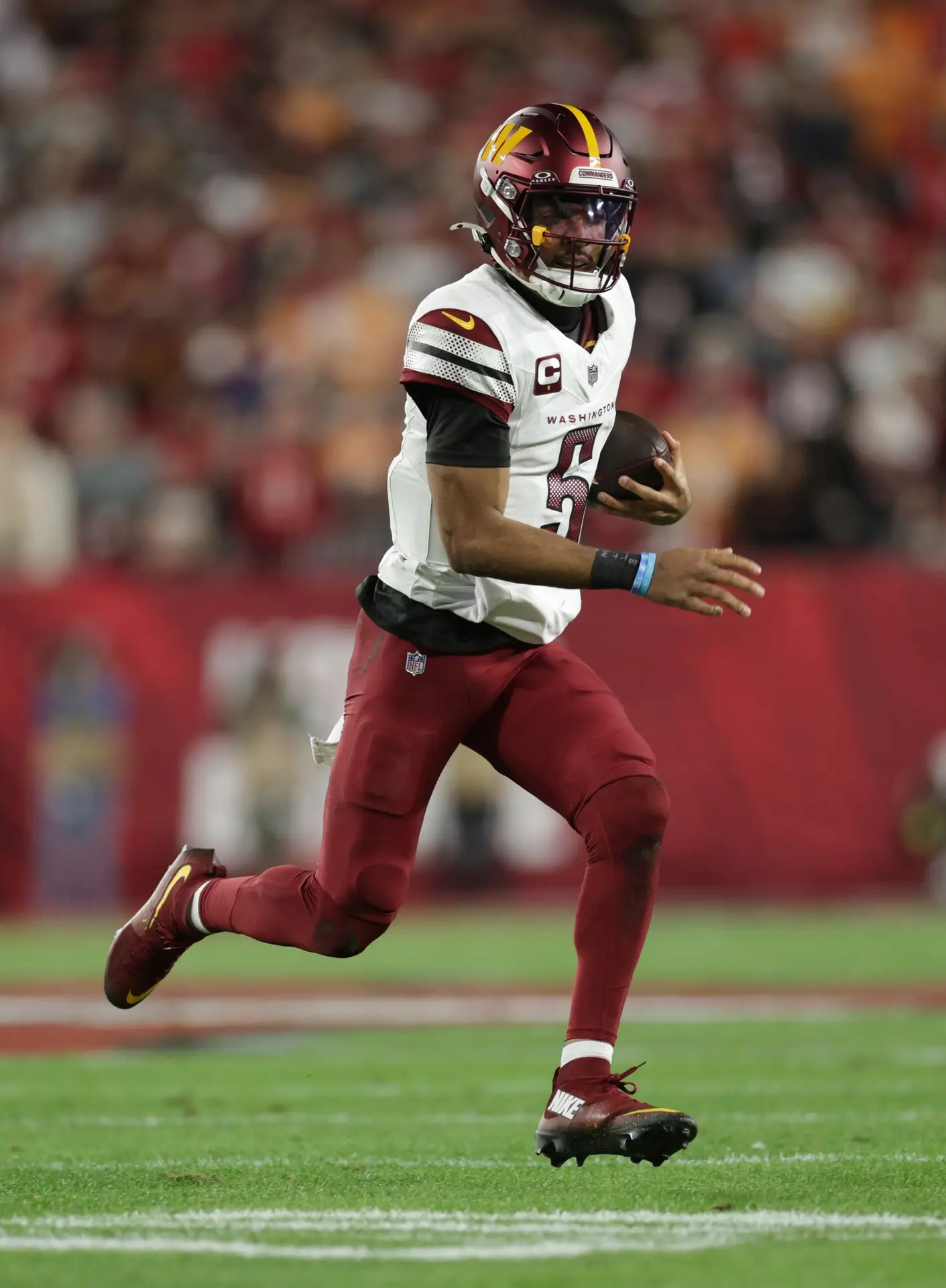 Jan 12, 2025; Tampa, Florida, USA; Washington Commanders quarterback Jayden Daniels (5) scrambles during the first quarter of a NFC wild card playoff against the Tampa Bay Buccaneers at Raymond James Stadium. Mandatory Credit: Nathan Ray Seebeck-Imagn Images