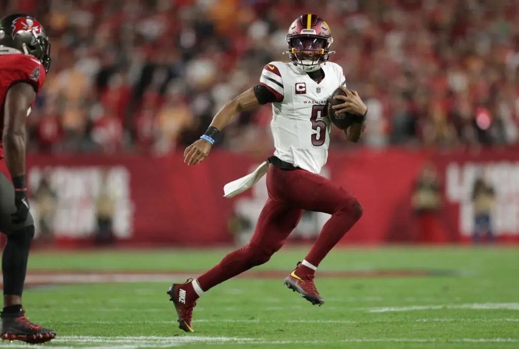 Jan 12, 2025; Tampa, Florida, USA; Washington Commanders quarterback Jayden Daniels (5) scrambles during the first quarter of a NFC wild card playoff against the Tampa Bay Buccaneers at Raymond James Stadium. Mandatory Credit: Nathan Ray Seebeck-Imagn Images