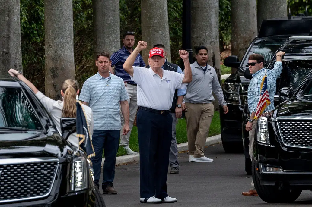 President Donald Trump raises his arms to supporters who gathered across the street from Trump International Golf Club in West Palm Beach to celebrate Presidents Day on Feb. 17. © [Greg Lovett/Palm Beach Post] / USA TODAY NETWORK via Imagn Images