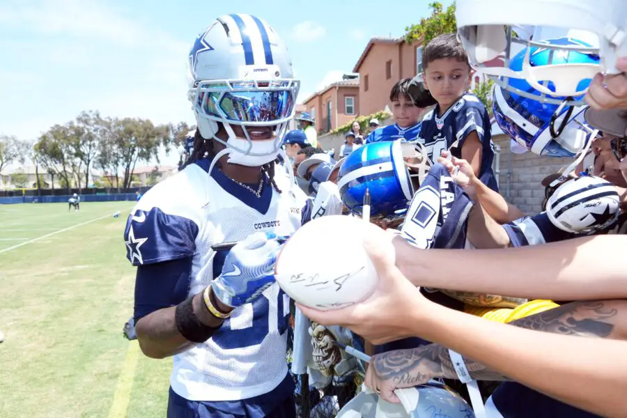 Dallas Cowboys receiver CeeDee Lamb (88) signs autographs during training camp at the River Ridge Fields