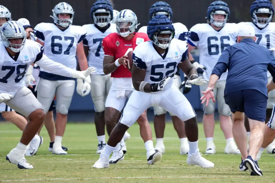 Dallas Cowboys quarterback Dak Prescott (4) prepares to take the snap as guard Tyler Booker (52) reacts at training camp at the River Ridge Fields