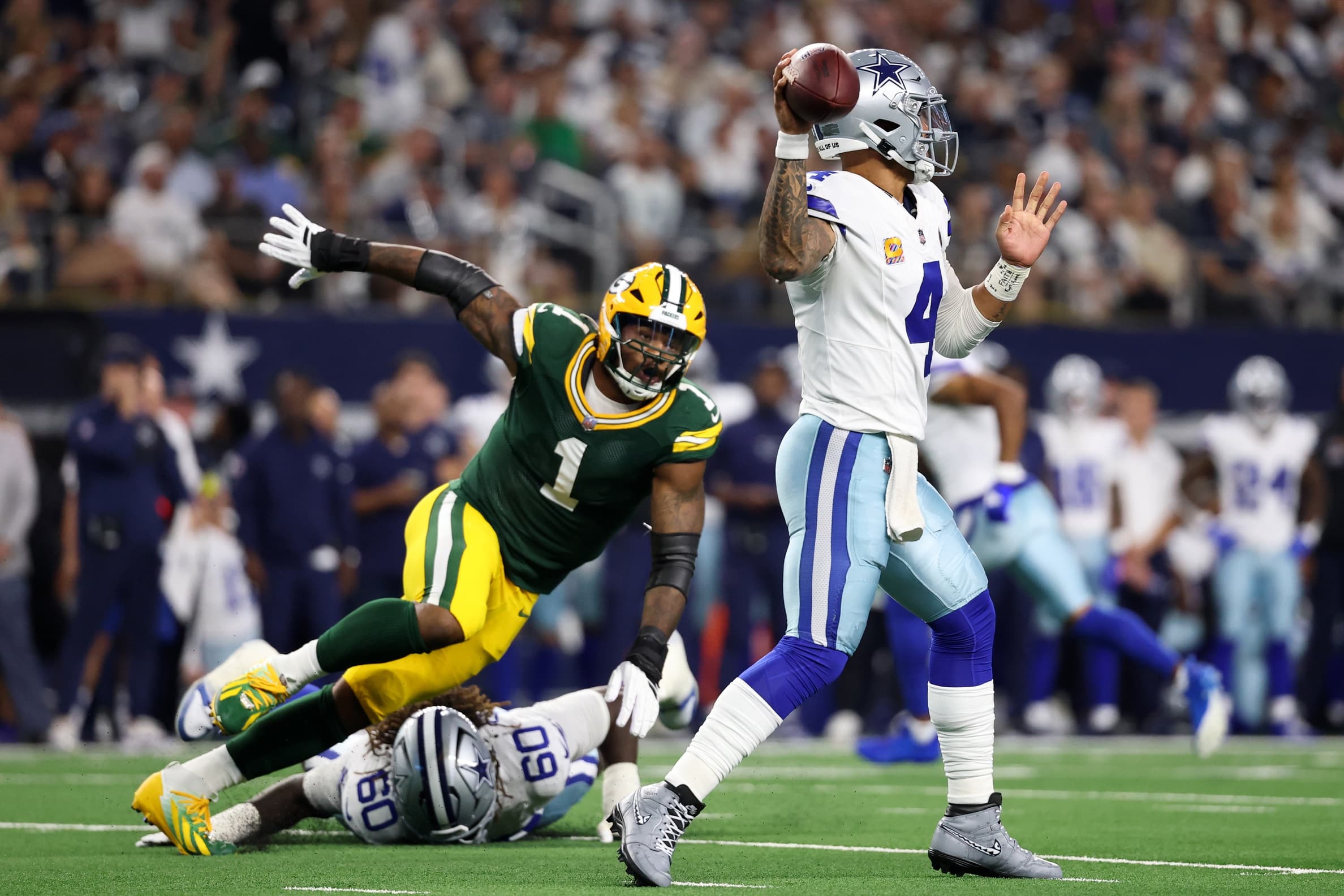Sep 28, 2025; Arlington, Texas, USA; Dallas Cowboys quarterback Dak Prescott (4) throws under pressure from Green Bay Packers defensive end Micah Parsons (1) in the first quarter at AT&T Stadium. Mandatory Credit: Kevin Jairaj-Imagn Images
