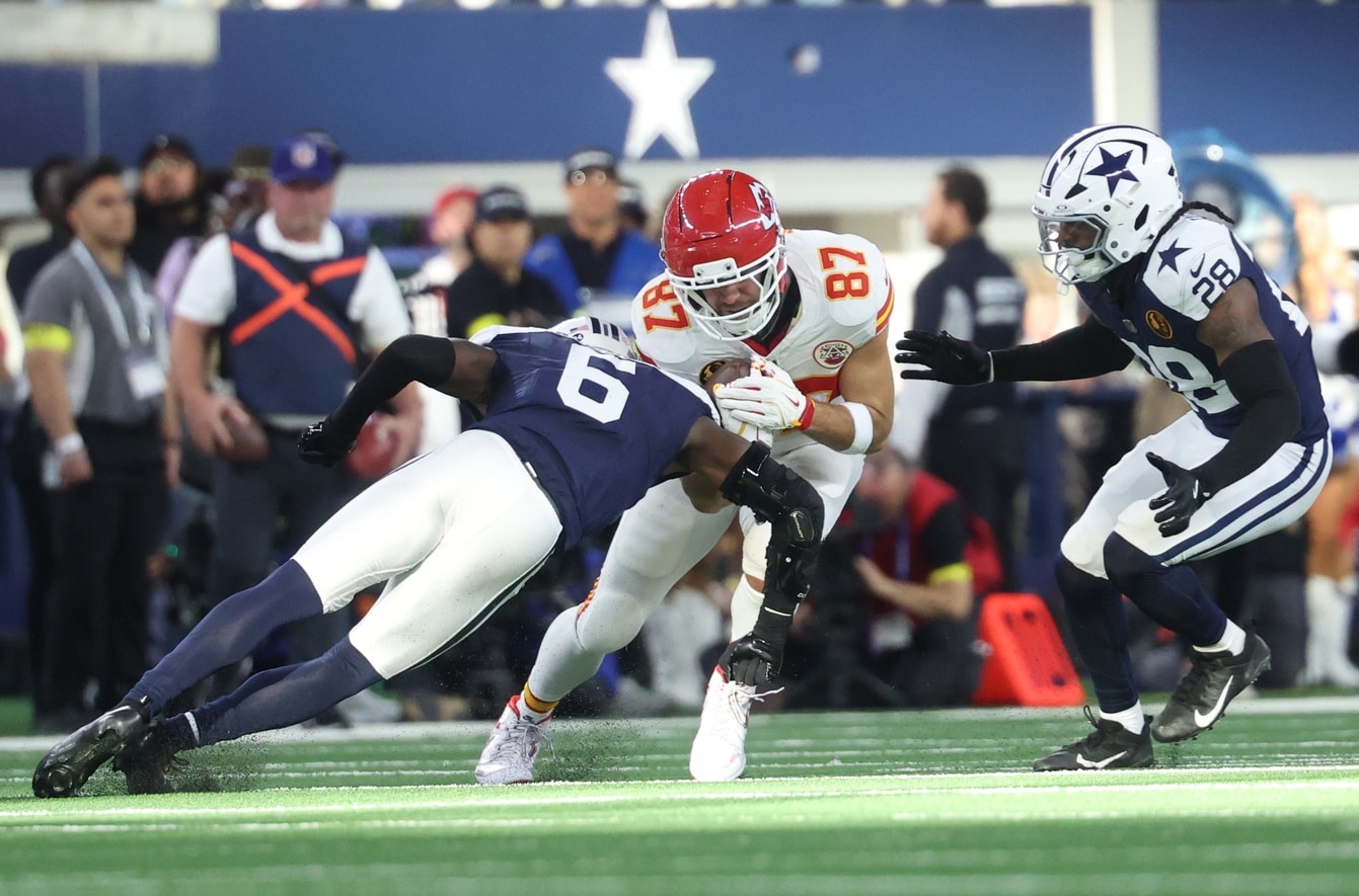 Nov 27, 2025; Arlington, Texas, USA; Kansas City Chiefs tight end Travis Kelce (87) runs with the ball against Dallas Cowboys safety Donovan Wilson (6) and Dallas Cowboys safety Malik Hooker (28) during the second quarter at AT&T Stadium. Mandatory Credit: Kevin Jairaj-Imagn Images