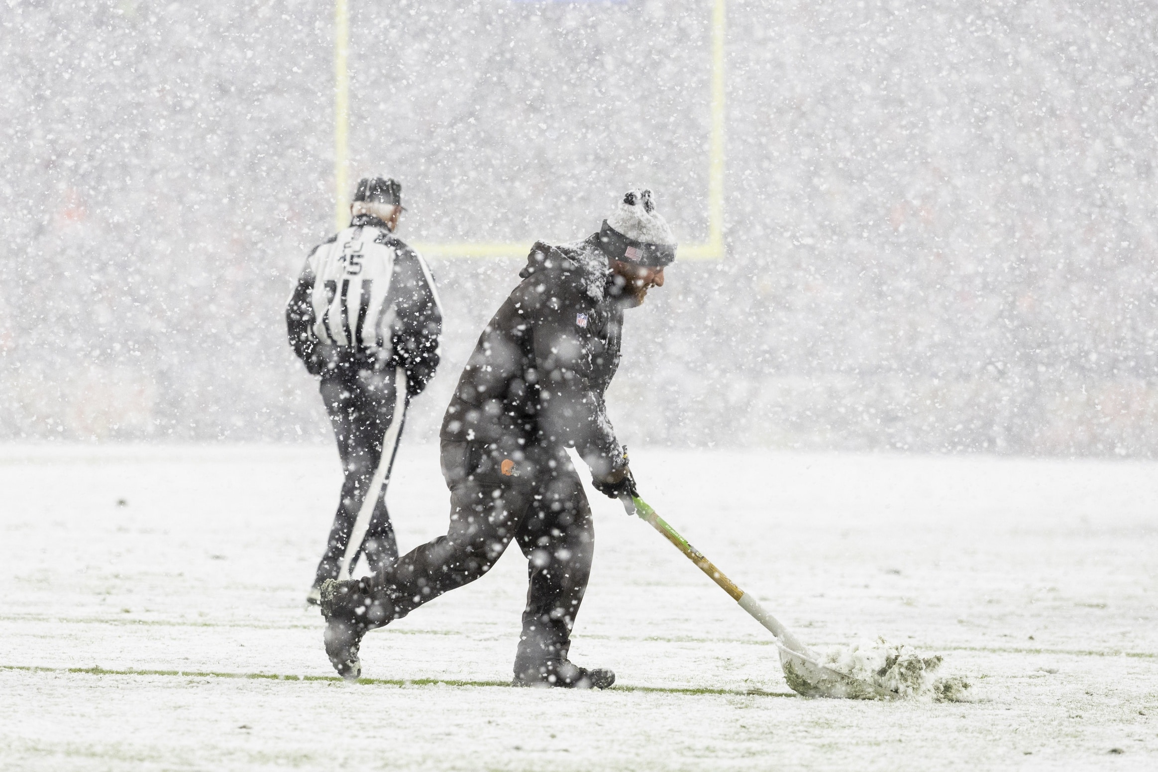 Nov 21, 2024; Cleveland, Ohio, USA; A grounds crew member shovels snow off the yard lines during the third quarter between the Cleveland Browns and the Pittsburgh Steelers at Huntington Bank Field Stadium. Mandatory Credit: Scott Galvin-Imagn ImagesNFL